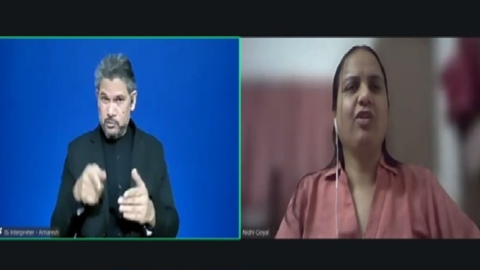 Screenshot of a Zoom meeting. Spotlighted are 2 windows. On the left is ISL Interpreter Amaresh and on the right is Nidhi Goyal, who is speaking. She is wearing a pink collared shirt.