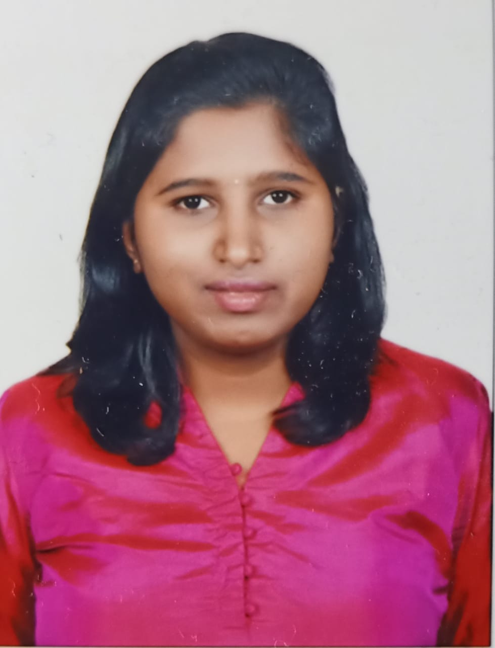 Chandana C is an in Indian woman with short black, shoulder-length hair. She is wearing a bright pink top, in a studio with a white background.