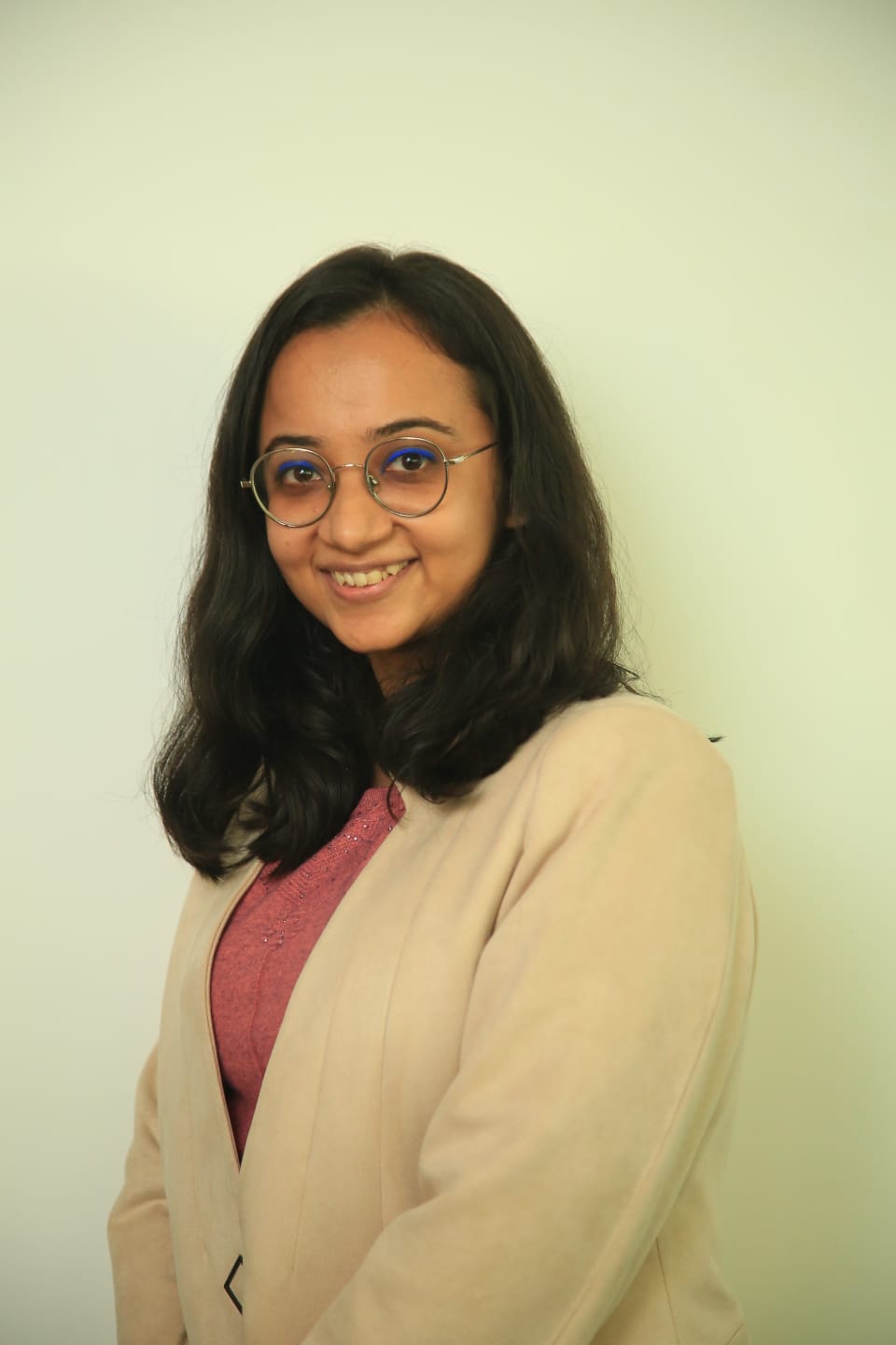 Himanshi Sardana is an Indian woman with dark shoulder-length hair. She is wearing glasses, and a cream coloured blazer over a pink top.