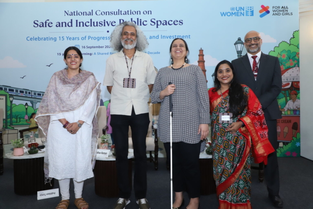 The panelists standing on a stage in front of their seats and a banner with the name of the event behind them. From left to right: Prabhleen Tuteja, Madhav Raman, Nidhi Goyal, Anita Kumar, and Gokul Narayan.